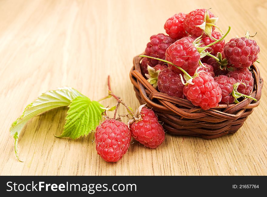Raspberries in the basket on the table