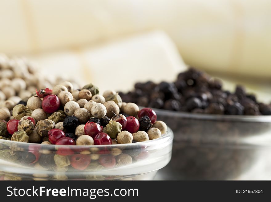 Close-up of mixed peppercorns in small glass bowl.