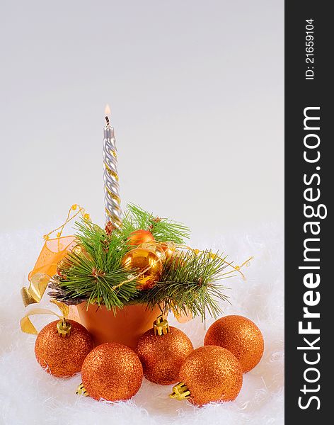 Christmas orange spheres and silver candles on the white fur