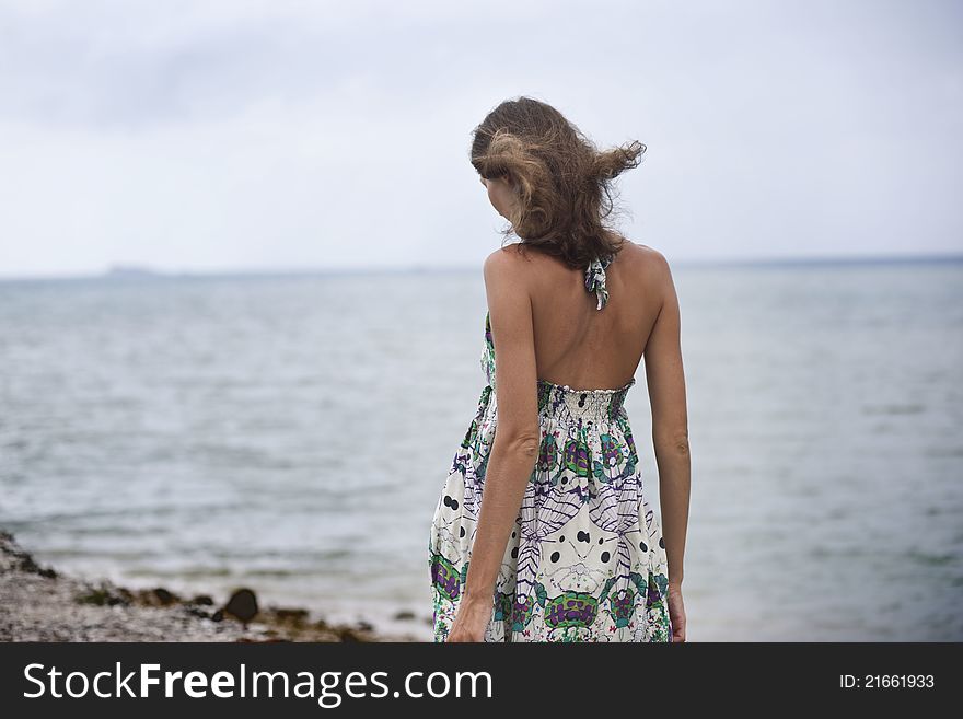 The girl goes to the beach, back, walk on the beach