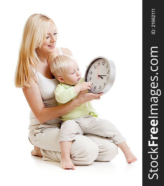 Mother displaying time to her son seating together on floor in studio