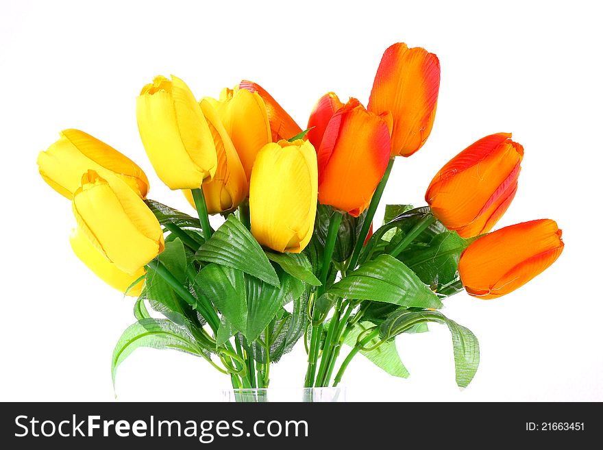 Plastic orange and yellow tulips on white background. Plastic orange and yellow tulips on white background