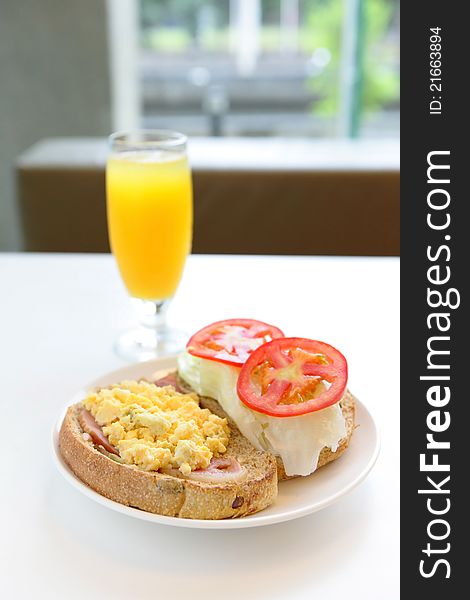 Delicious breakfast include egg, tomato , toast and orange juice, good for health with window. Delicious breakfast include egg, tomato , toast and orange juice, good for health with window