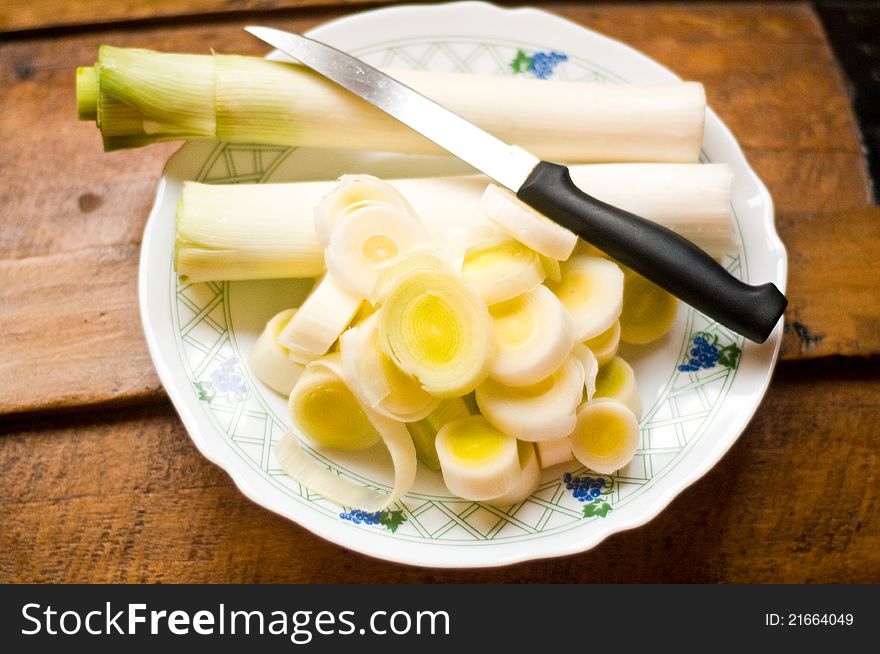 Fresh cut leek and knife on a plate