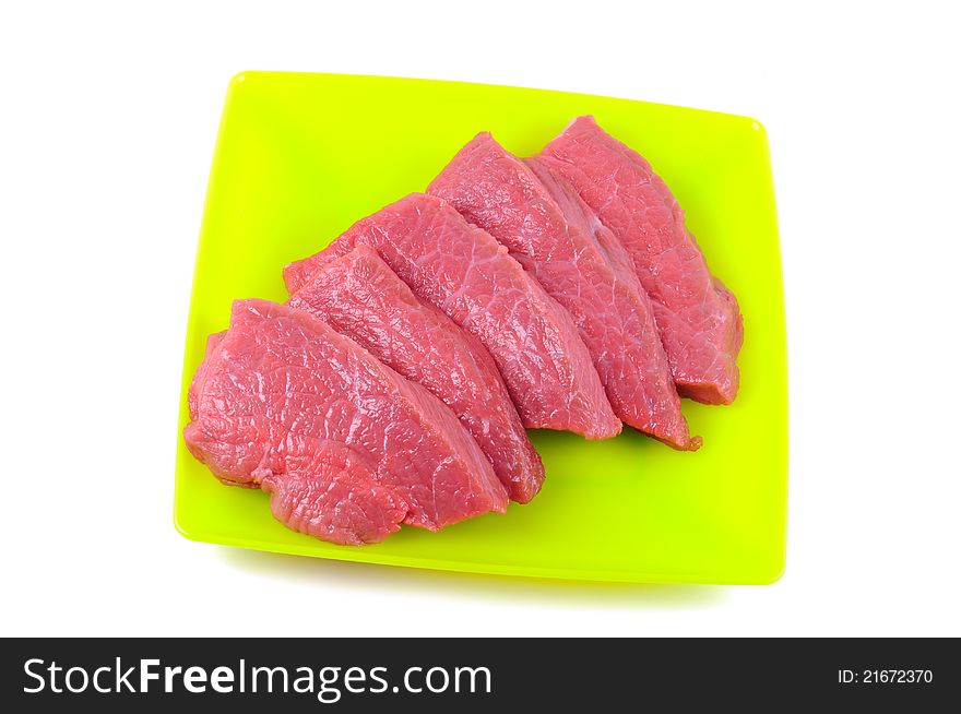 Fresh raw meat on a plate, on a white background