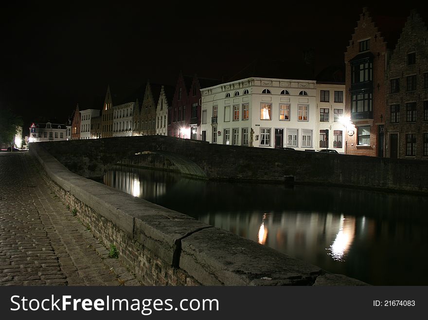 View of some ancient houses and a canal with a bridge in the historical town of Brugge in Belgium. View of some ancient houses and a canal with a bridge in the historical town of Brugge in Belgium.