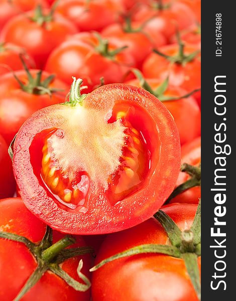 Single cut tomato on top of blurred tomato rows. Single cut tomato on top of blurred tomato rows