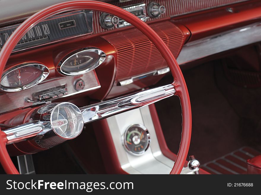 A steering wheel in a classic automobile. A steering wheel in a classic automobile