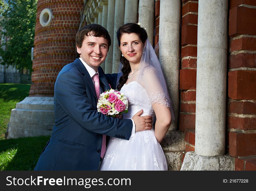 Happy bride and groom with bouquet in wedding walk