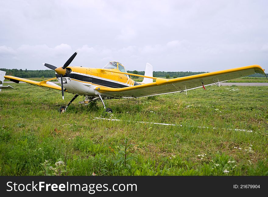 Light aircraft parked on the background of a cloudy sky