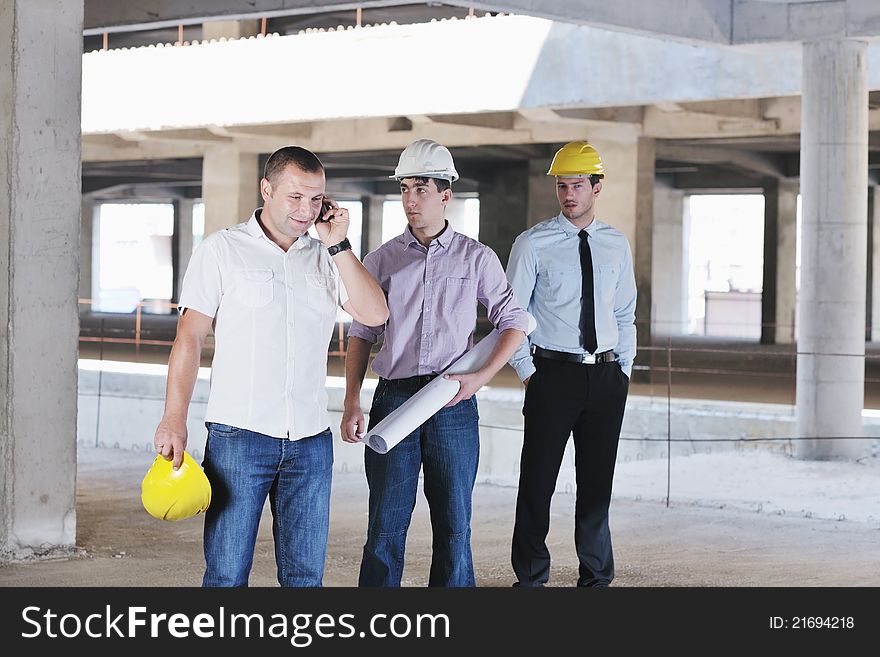 Team of business people in group, architect and engeneer on construciton site check documents and business workflow on new building. Team of business people in group, architect and engeneer on construciton site check documents and business workflow on new building