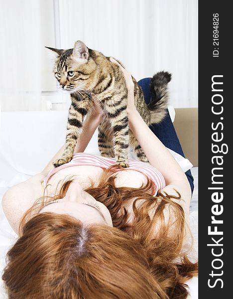 Young woman playing with a tabby cat. Young woman playing with a tabby cat