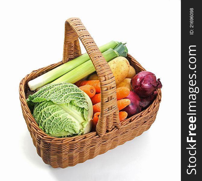 A selection of fresh vegetables in a woven basket with a handle. A selection of fresh vegetables in a woven basket with a handle.