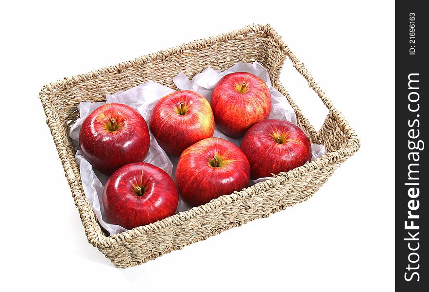 Six Gala apples in a woven seagrass basket. Isolated on a white background. Six Gala apples in a woven seagrass basket. Isolated on a white background.