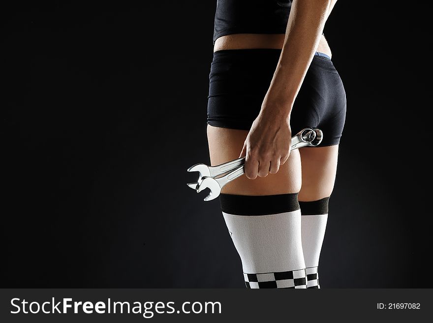 Sexy woman with wrench black background