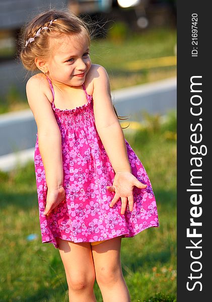 A beautiful girl making gesture I don`t know with her arms (hands),outdoor.