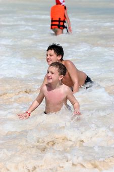 Boys Playing In Ocean Waves Stock Photo