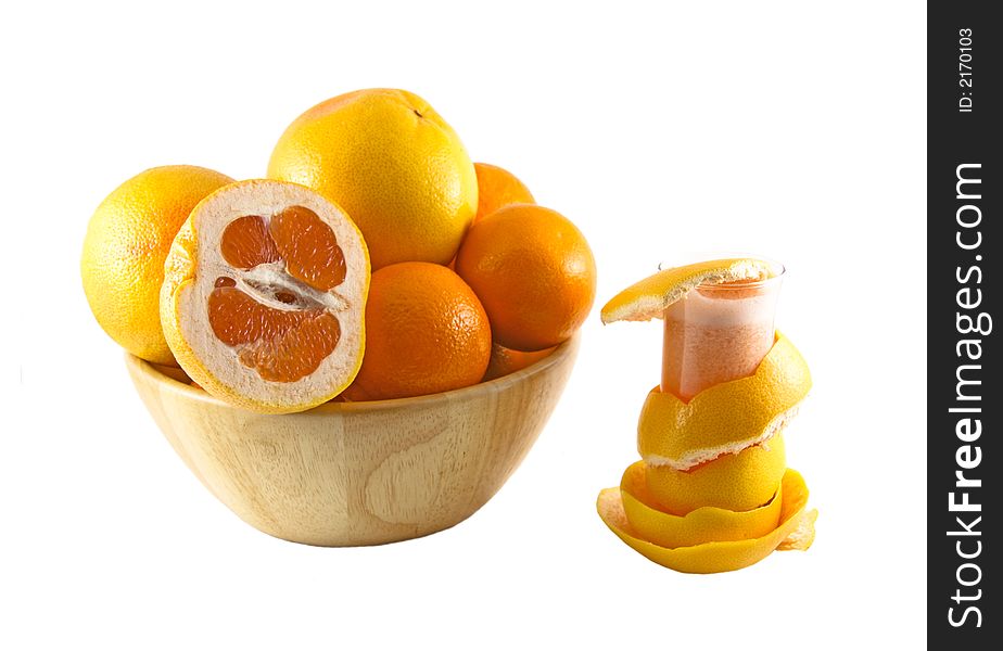 Glass with juice, grapefruit peel and a basket full of fruits selected on a white background