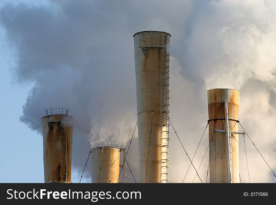 The chimney of a factory with white smoke. The chimney of a factory with white smoke