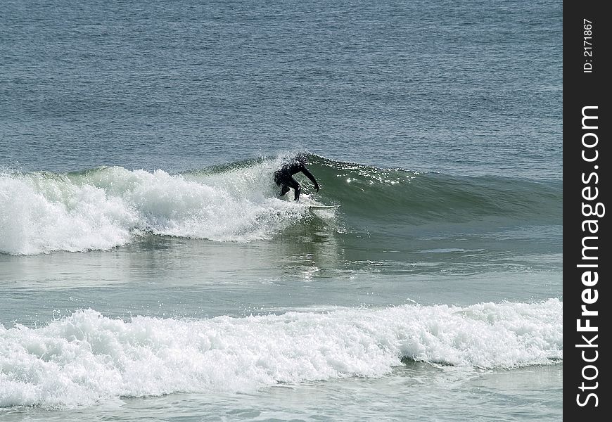 A surfer wears a wet-suit while surfing in the cold Atlantic Ocean along the Jersey shore in early Spring. A surfer wears a wet-suit while surfing in the cold Atlantic Ocean along the Jersey shore in early Spring.