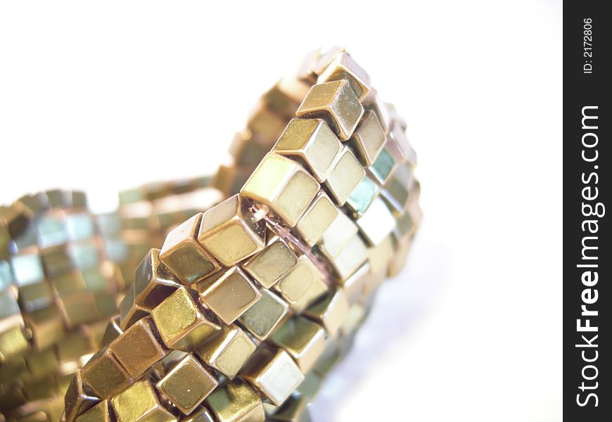 Golden bracelet closeup on a white background, high contrasts. Golden bracelet closeup on a white background, high contrasts