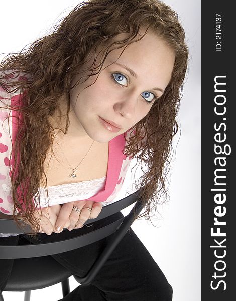 Pretty young brunette woman with curly hair and large blue eyes, seated. Pretty young brunette woman with curly hair and large blue eyes, seated