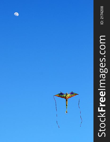 Colorful dragon kite against blue sky with moon. Colorful dragon kite against blue sky with moon