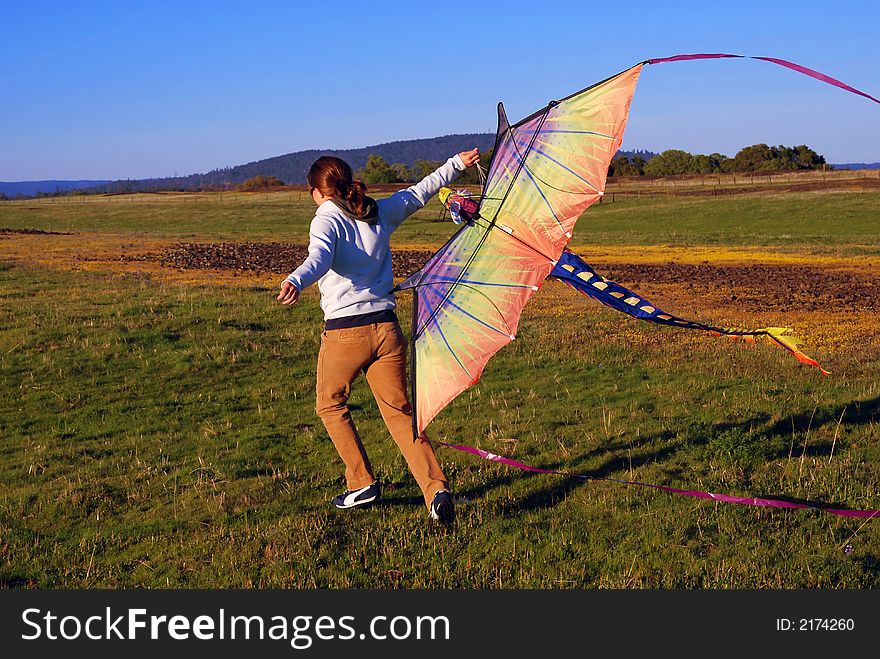 Young girl running with kite