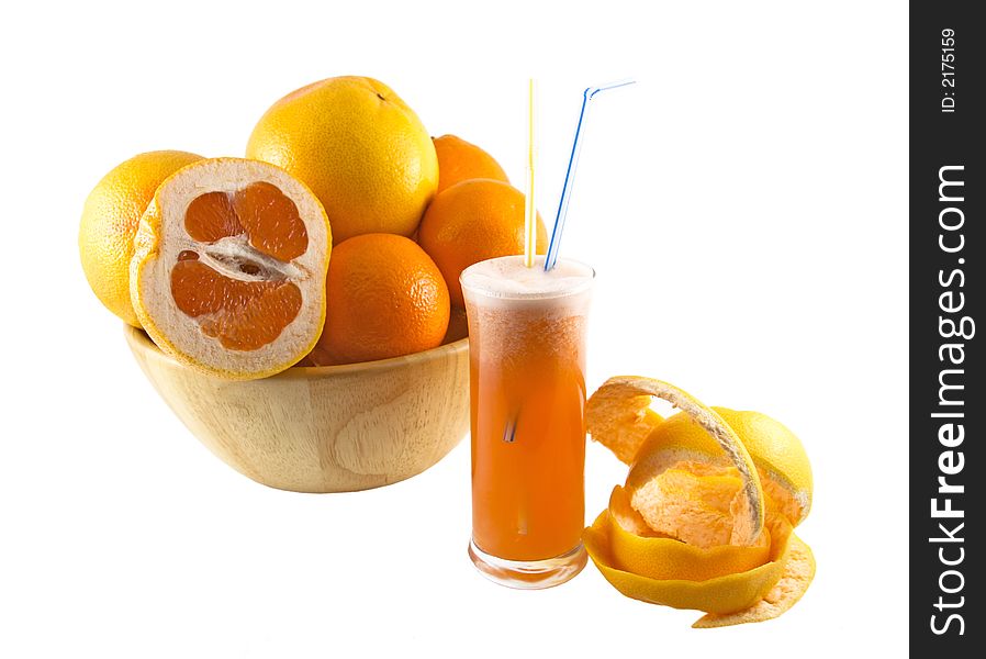 Glass with juice, grapefruit peel and a basket full of fruits selected on a white background