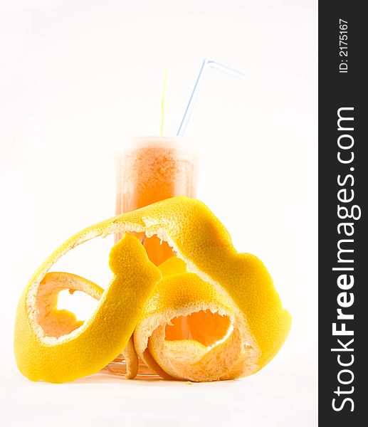 Glass with juice and a grapefruit peel selected on a white background