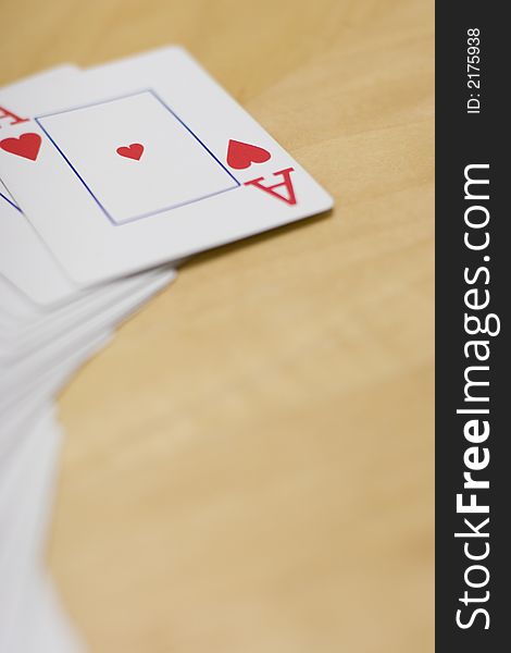 Deck of cards spread out on a wooden table with the Ace of Hearts side up. Deck of cards spread out on a wooden table with the Ace of Hearts side up