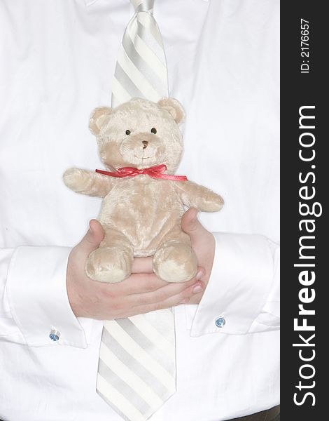 Businessman holds in his hands a cute teddy bear for comfort. Businessman holds in his hands a cute teddy bear for comfort