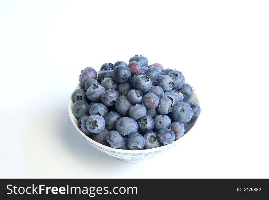 Bowl of ripe blueberries on a white back ground