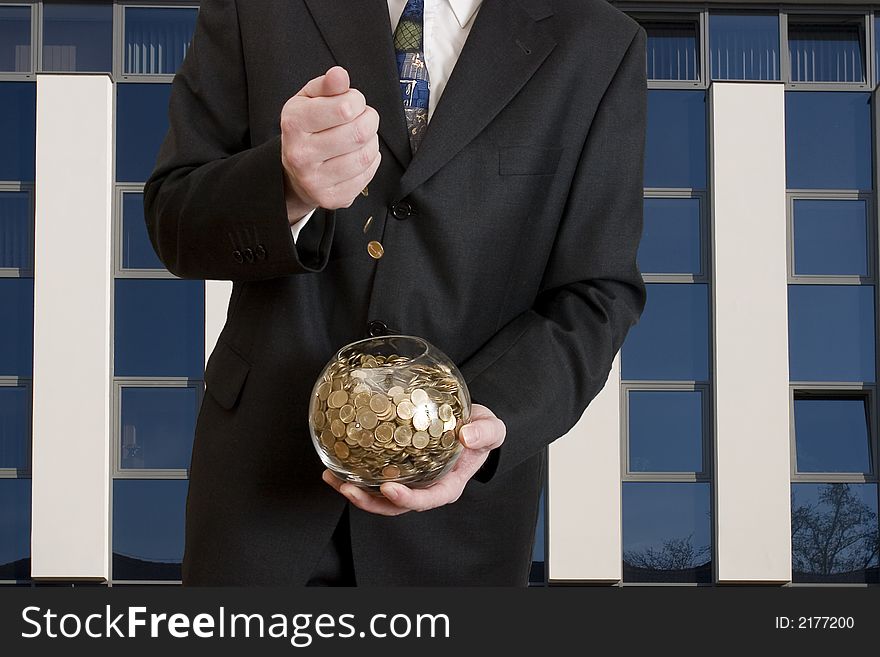 Business man with a glass sphere which include a lot of coins. Business man with a glass sphere which include a lot of coins