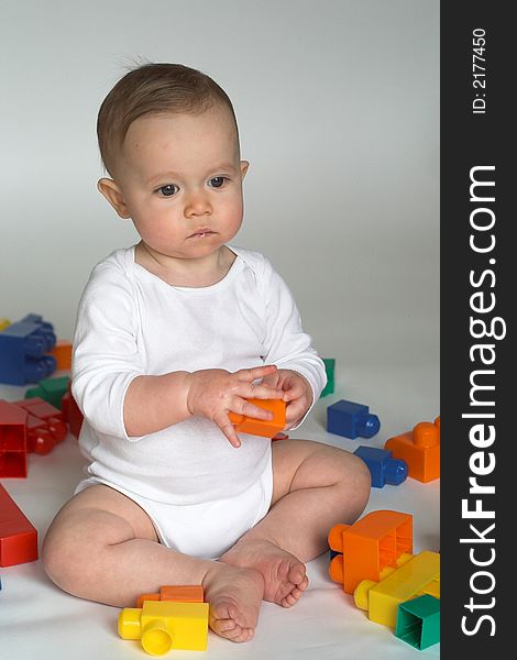 Image of cute baby playing with colorful building blocks. Image of cute baby playing with colorful building blocks