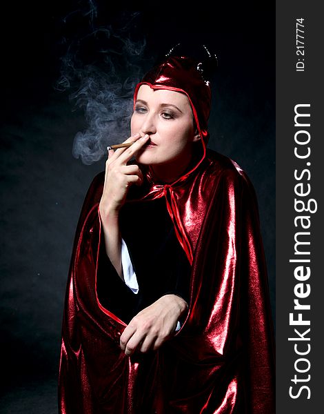 Smoking women in devil costume. Make-up black background. Smoking women in devil costume. Make-up black background.