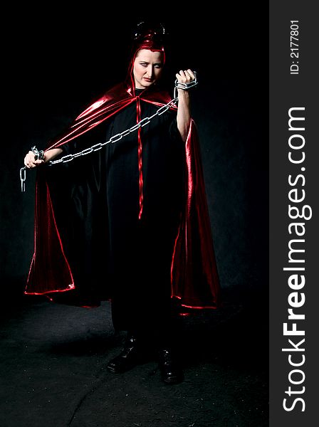 Women in devil costume with chain in hands. Make-up black background. Women in devil costume with chain in hands. Make-up black background.