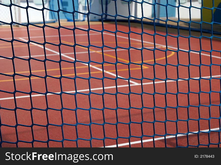 Blue rope fence in focus with basketball court in background. Blue rope fence in focus with basketball court in background