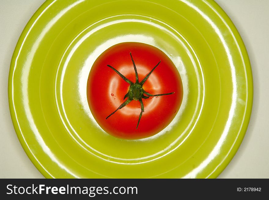 Red tomato on green plate