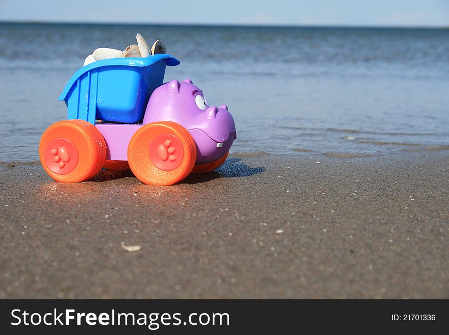 The toy truck on the canada beach, truck is loaded with a shell. The toy truck on the canada beach, truck is loaded with a shell.