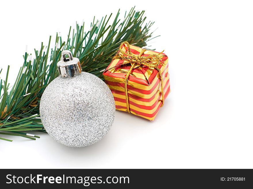 Christmas silver ball, red and yellow striped box and spruce branch. Christmas silver ball, red and yellow striped box and spruce branch