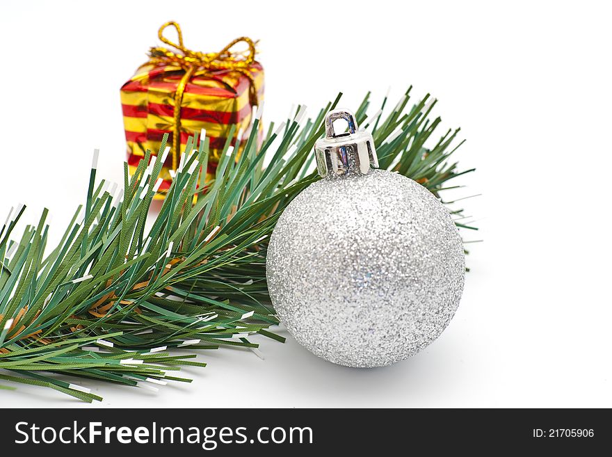 Christmas silver ball, red and yellow striped box and spruce branch. Christmas silver ball, red and yellow striped box and spruce branch