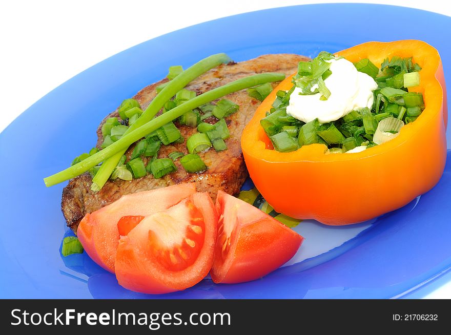 Meat main course served with  vegetables on a blue plate. Meat main course served with  vegetables on a blue plate