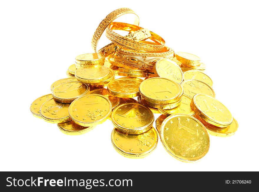 Gold coins and bracelets on a white background, whide lens shot. Gold coins and bracelets on a white background, whide lens shot