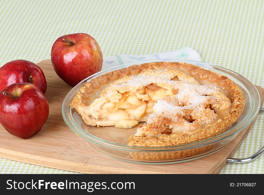 Sliced apple pie and apples on a tray