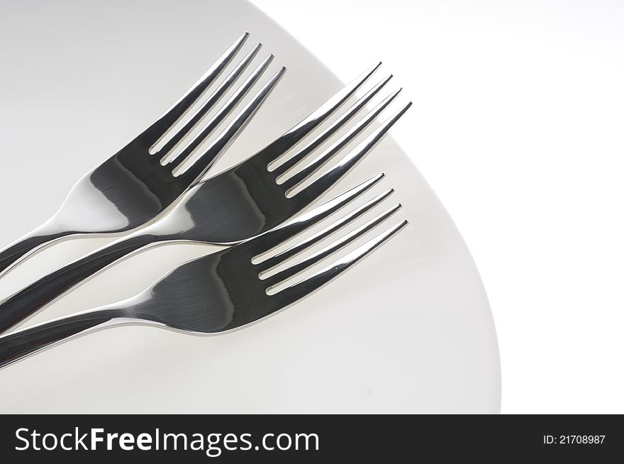 Forks on a plate isolated over white background. Forks on a plate isolated over white background