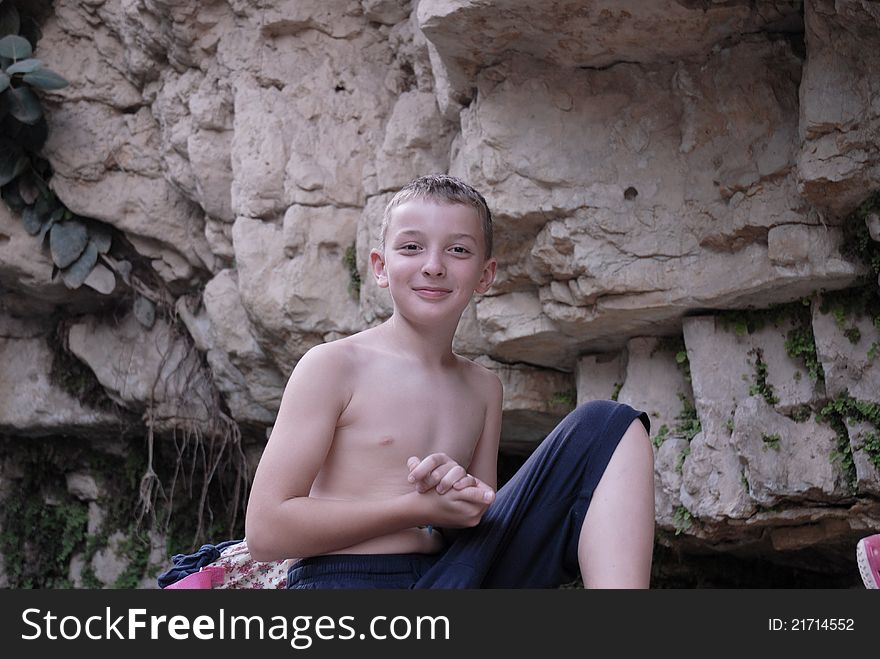 Boy Posing On The Background Of Rock
