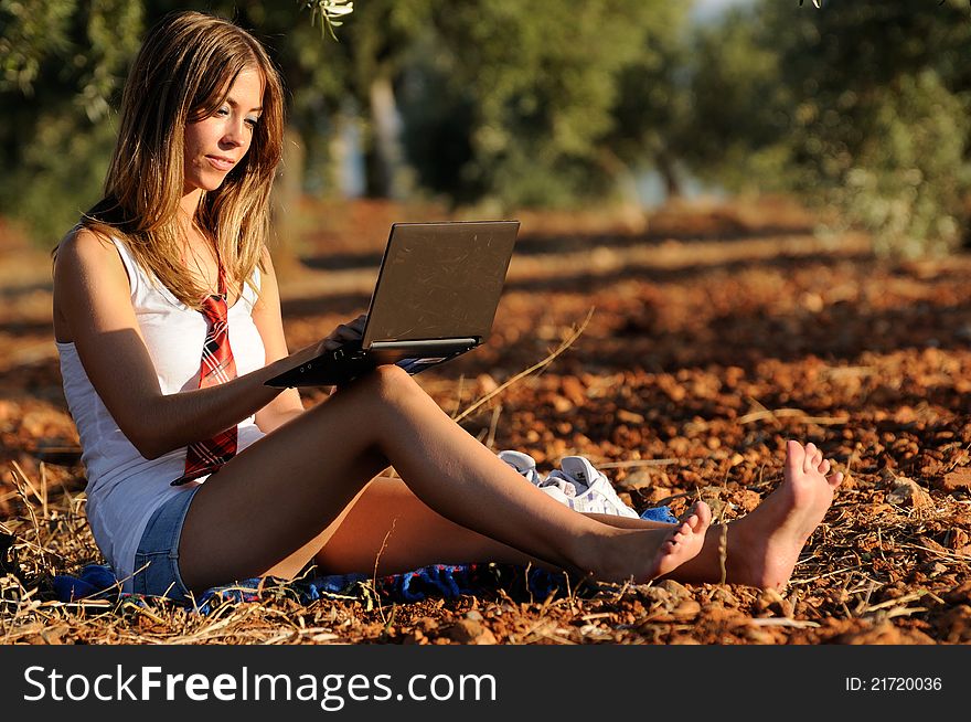 Girl with a laptop in a field in autumn