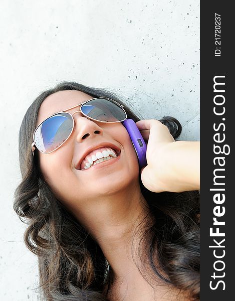 Young beautiful woman with sunglasses talking on phone. Young beautiful woman with sunglasses talking on phone