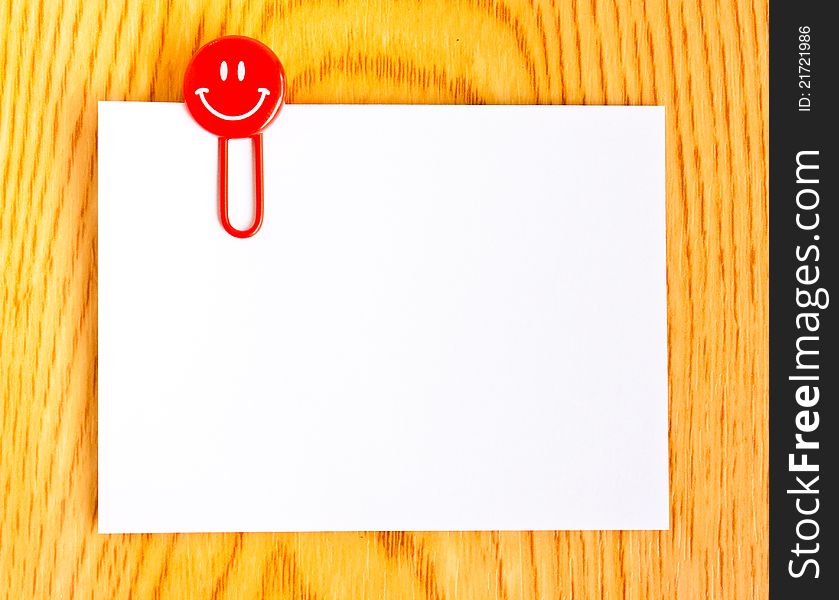 Close up of a red paper clip and white paper